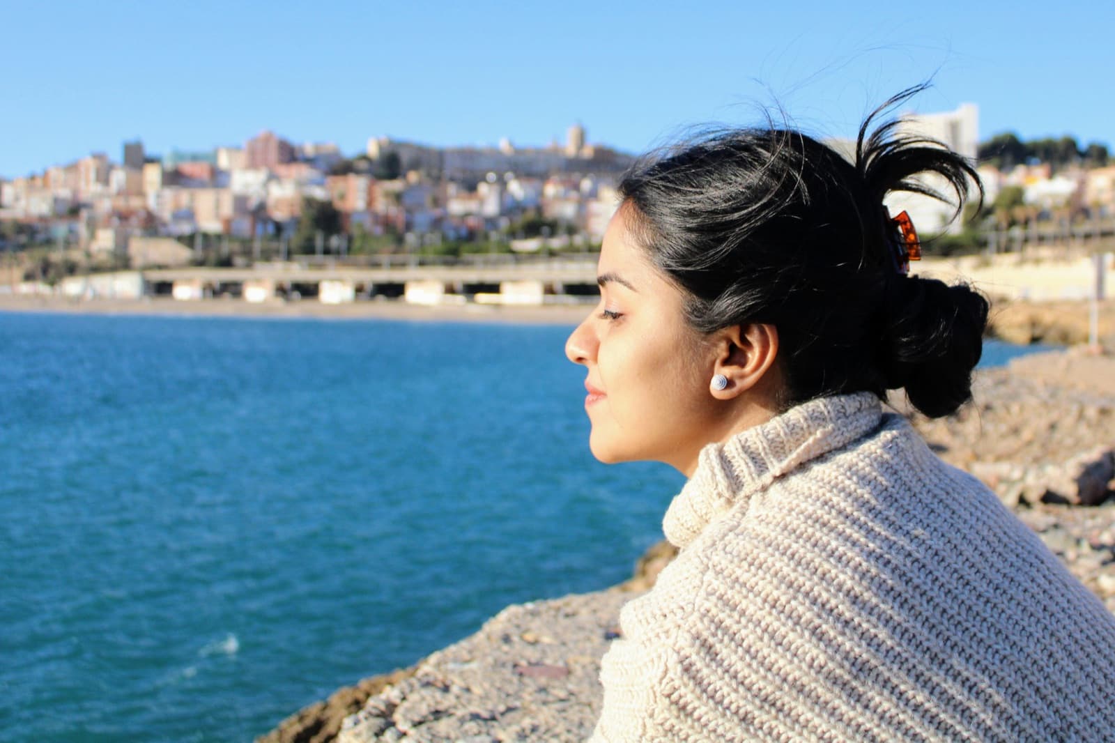 Mujer contemplando la costa mediterránea con vistas a la ciudad