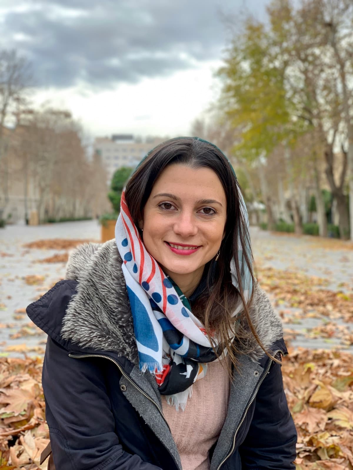 Mujer joven sonriendo en un parque español en otoño
