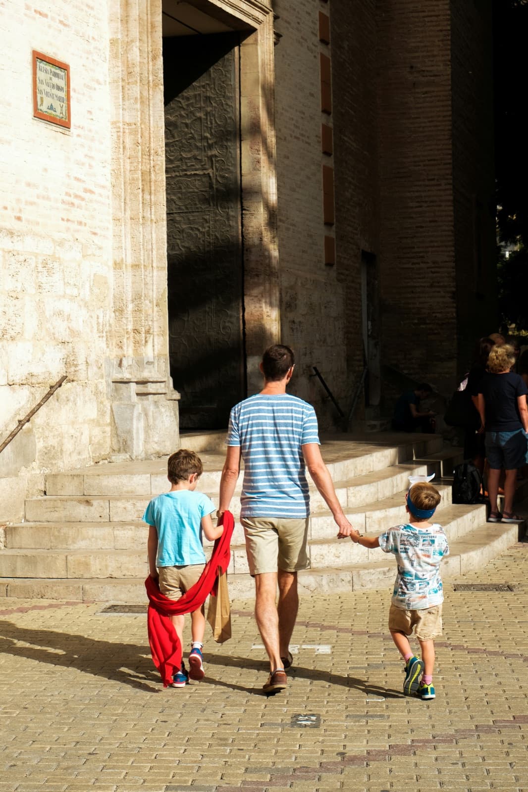 Padre paseando con sus hijos por una plaza andaluza